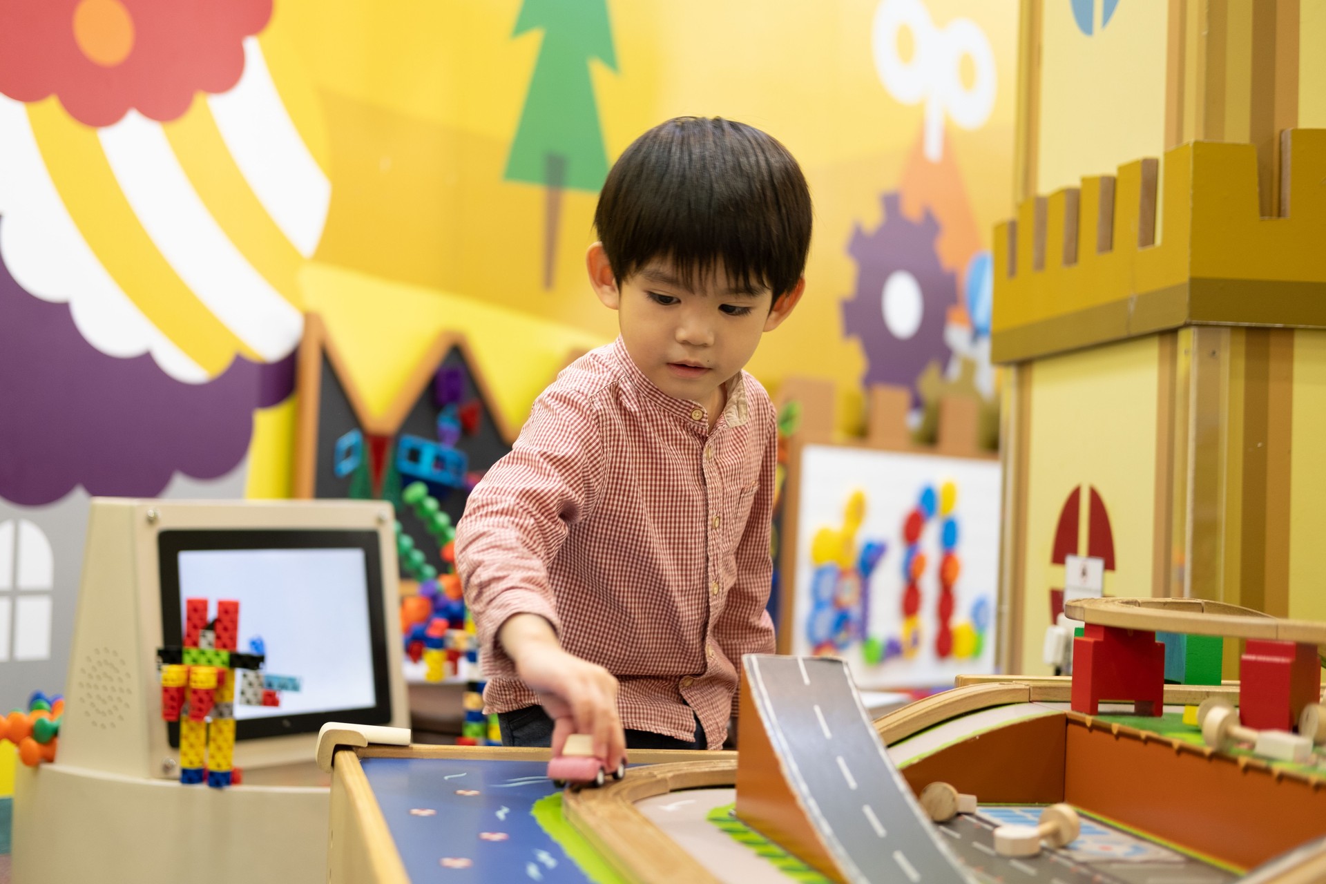 Little Asian boy playing with toy car in the children's play park